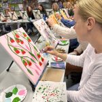 Adults engaged in a lively painting class